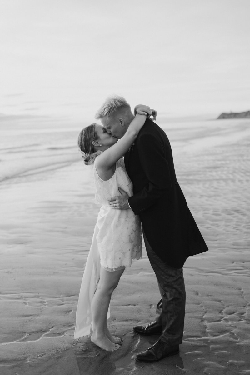 Natalie and Spencer sharing a kiss beside the sea