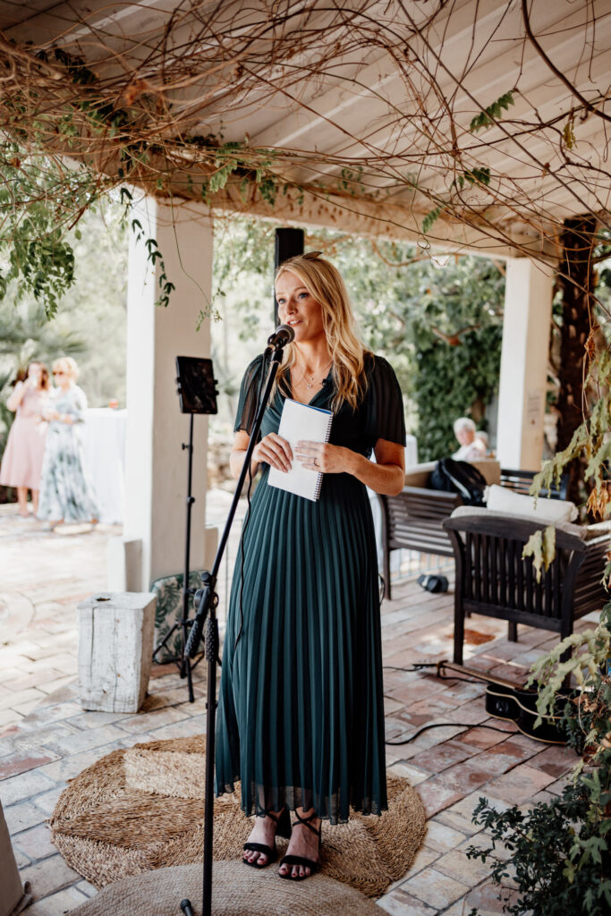 Guest giving a reading beneath the villa's vine-covered terrace