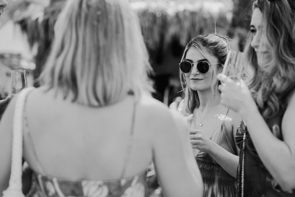 Black-and-white photograph of wedding guests talking outdoors