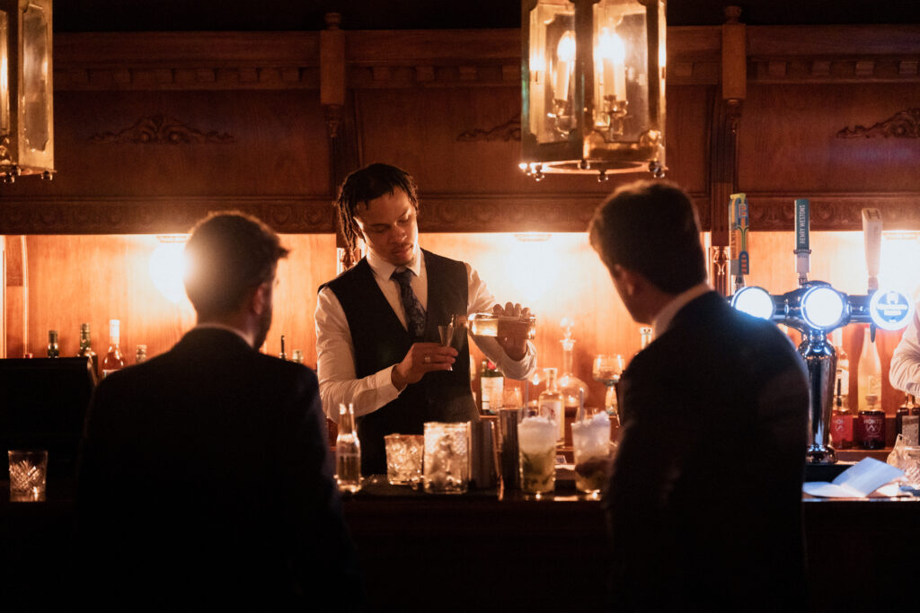 Wedding guests talking at the warmly lit bar