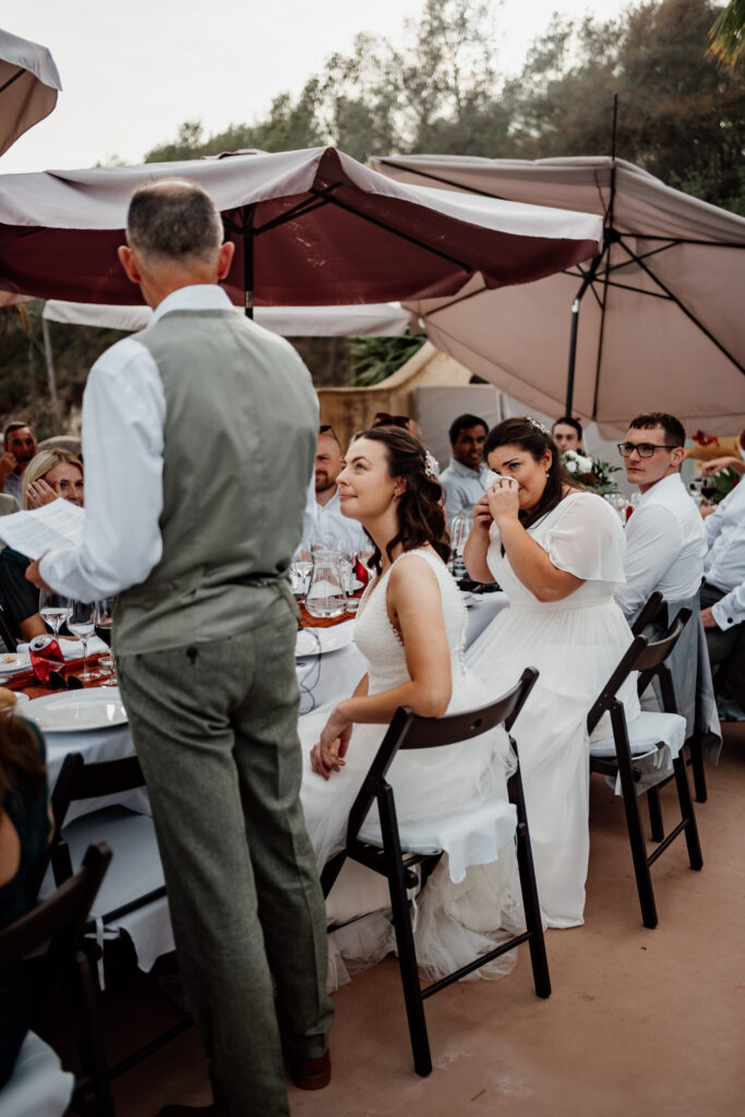 A guest giving a speech beside the outdoor reception table
