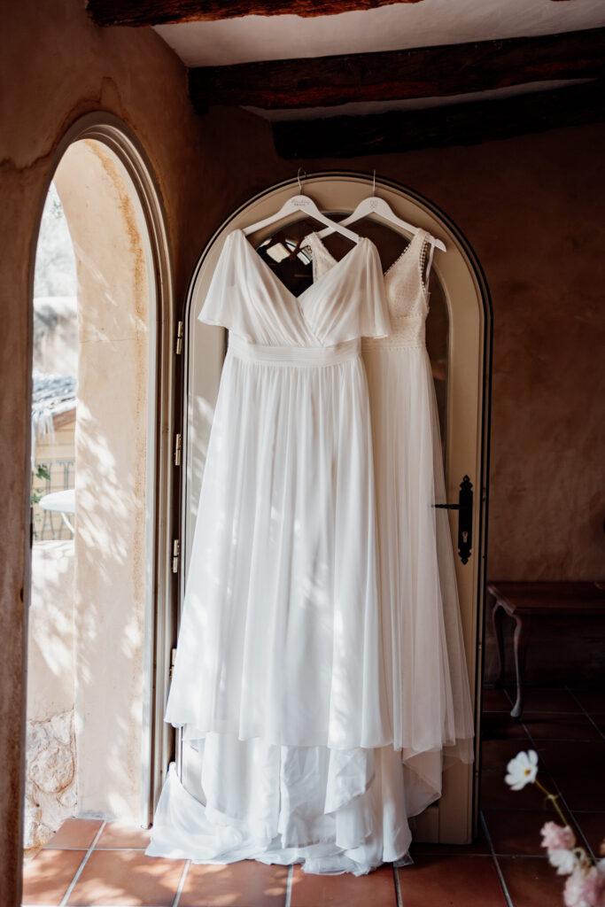 Wedding dress hanging on an arched mirror in the villa bedroom