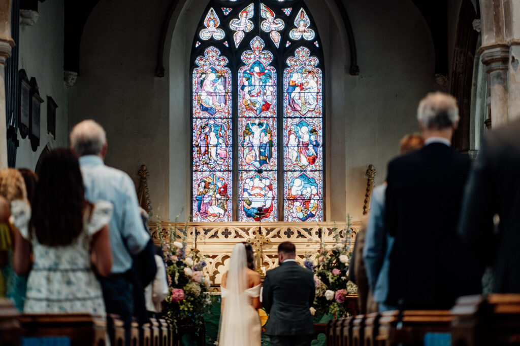 Wedding ceremony beneath a church stained-glass window
