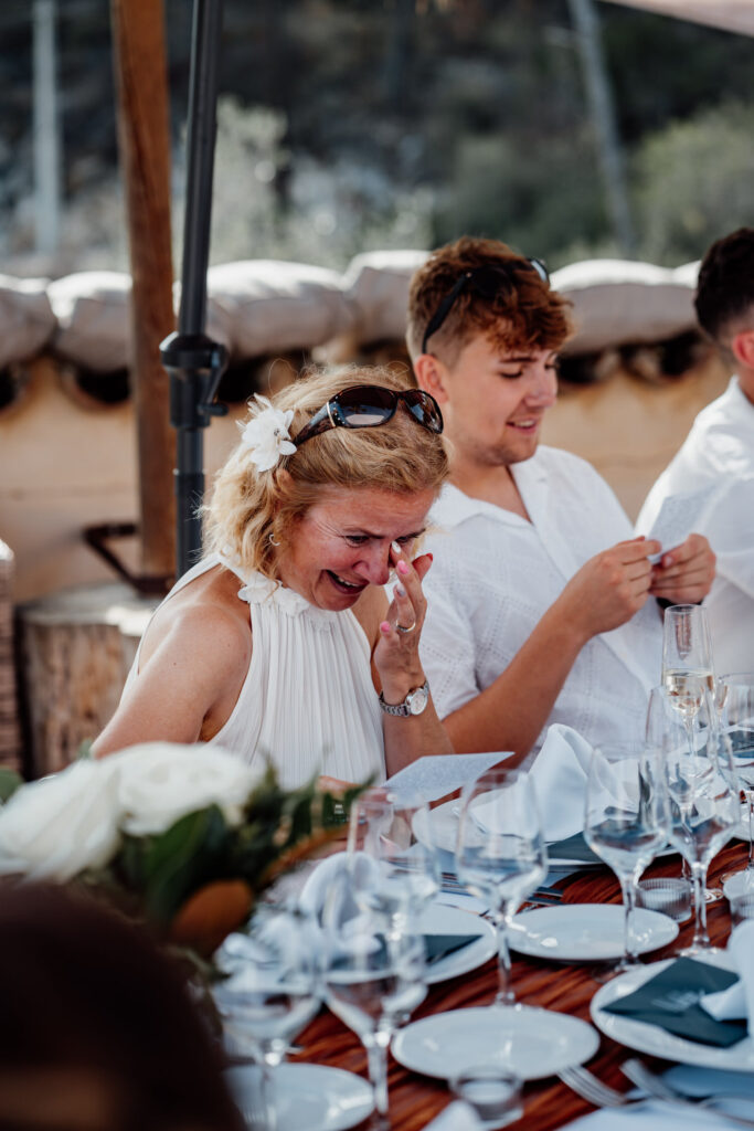 Two reception guests looking down at a phone beside their place settings