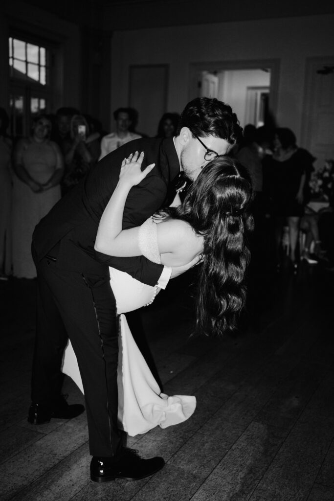 Black-and-white photograph of the groom dipping the bride on the dance floor