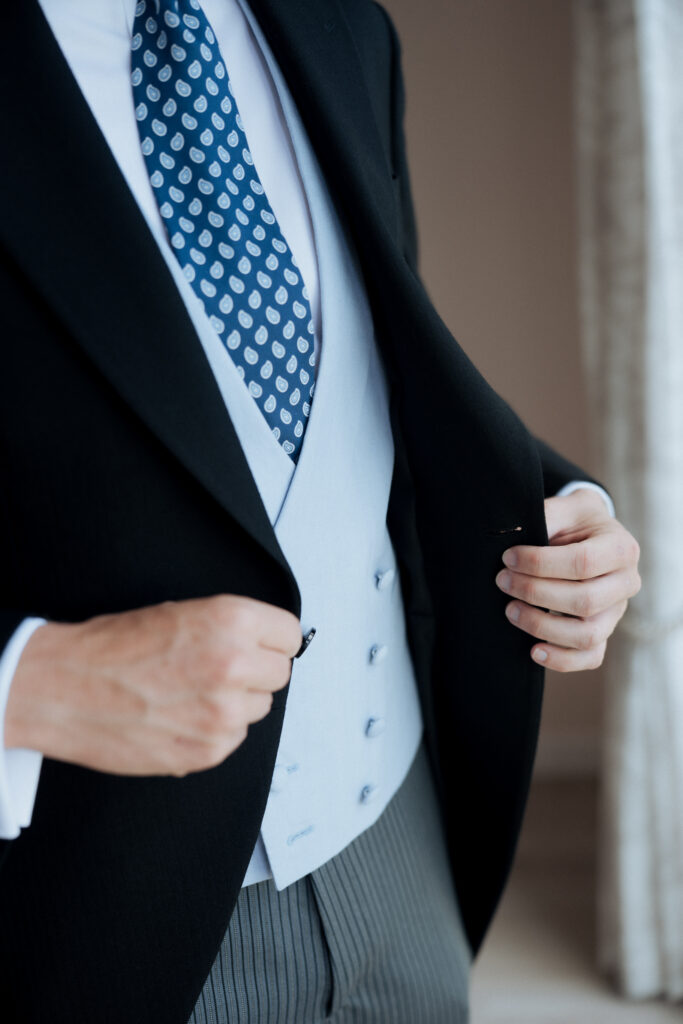 Close-up of the groom's patterned blue tie and pale waistcoat