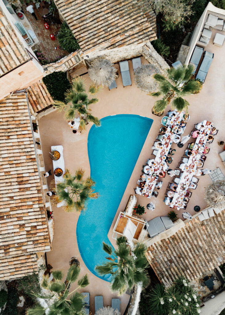 Overhead view of a swimming pool and long wedding reception tables