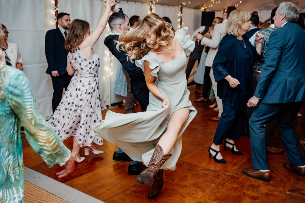 Bride spinning on the dance floor surrounded by guests