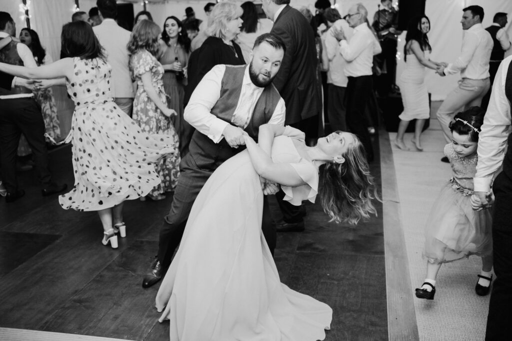 Black-and-white photograph of the bride dancing with a guest