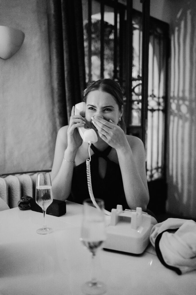 Black-and-white photograph of a guest wiping her eyes at the reception