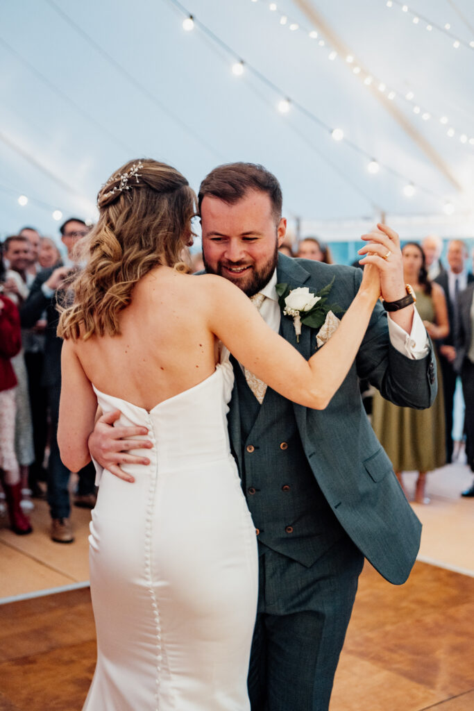 Close-up of newlyweds holding each other during their first dance