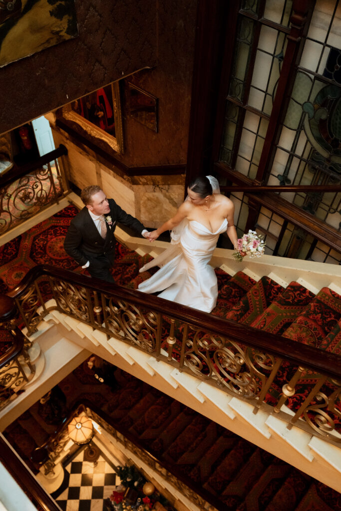 Overhead view of newlyweds holding hands on the staircase