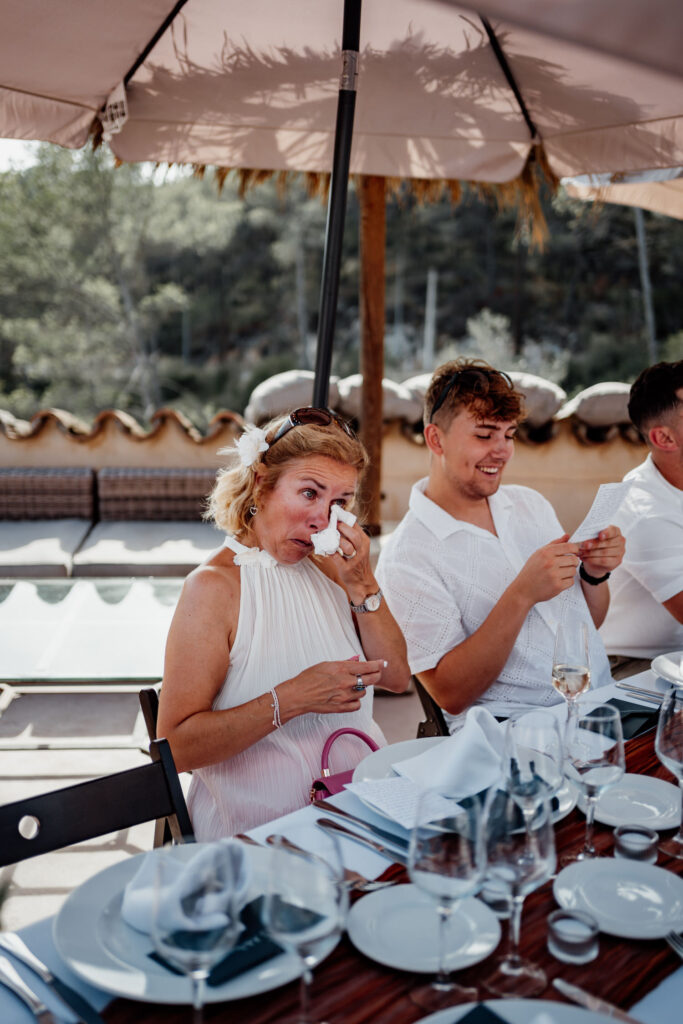 Guests looking at their phones at a poolside reception table