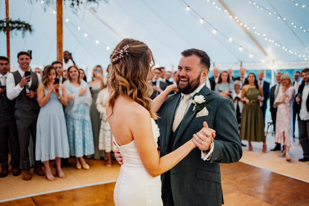 Bride and groom beginning their first dance in a fairy-lit marquee