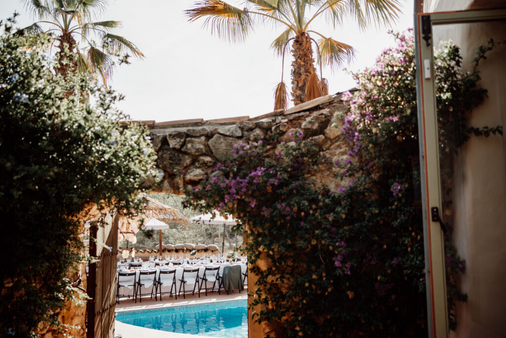 Poolside terrace viewed through a flower-covered doorway