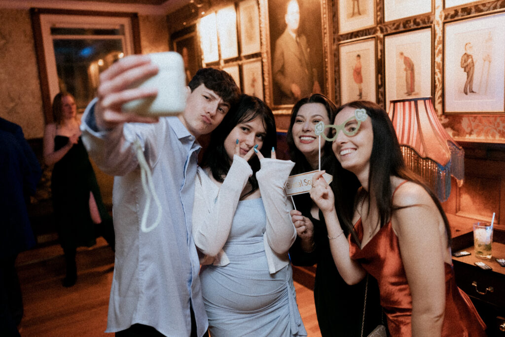 Wedding guests posing together for a phone selfie