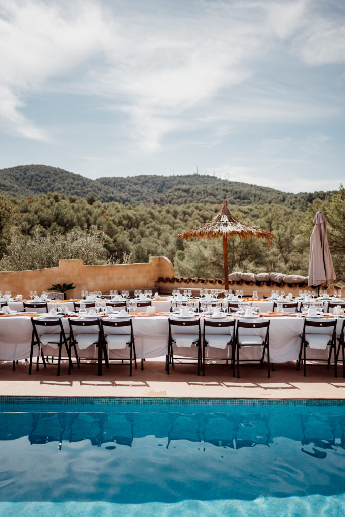 Poolside reception tables overlooking wooded hills