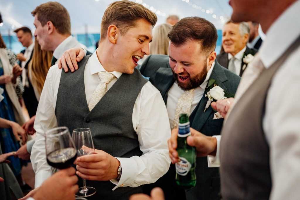 Groom laughing with guests on the marquee dance floor