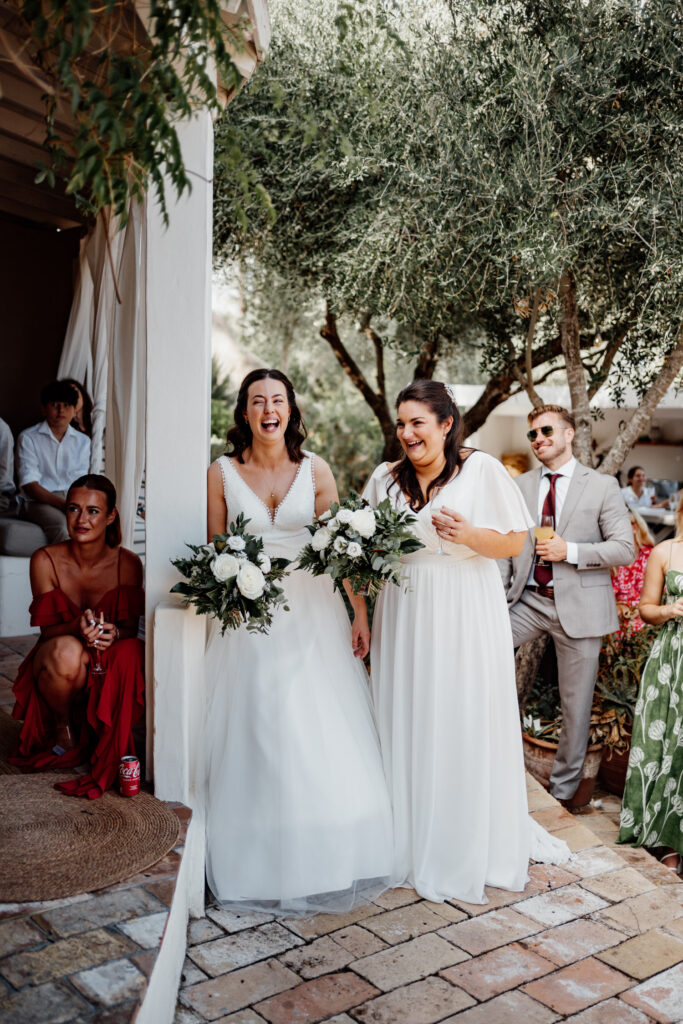 Newlyweds laughing together outside the villa doorway