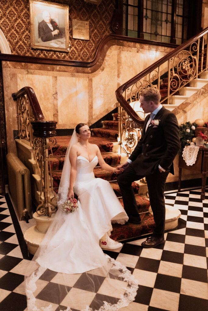 Bride stepping down the staircase while holding the groom's hand