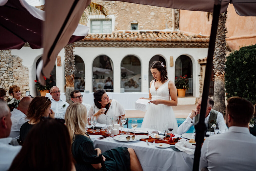 Bride speaking to guests at the poolside wedding breakfast