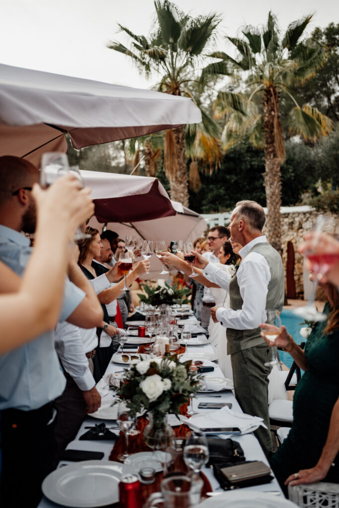 Guests raising glasses in a toast beside the swimming pool