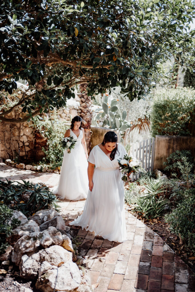 Brides walking along a shaded stone garden path