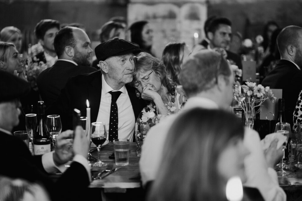 Emotional image of a couple leaning into one another during wedding speech