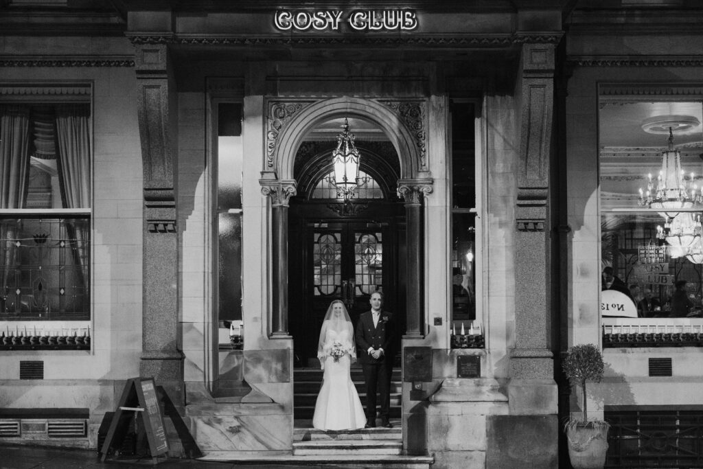 Black-and-white view of a bride framed by a grand entrance doorway