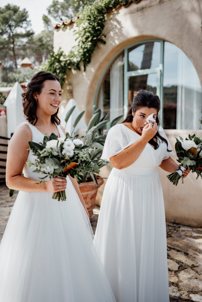 Bride wiping away a tear beside her smiling partner