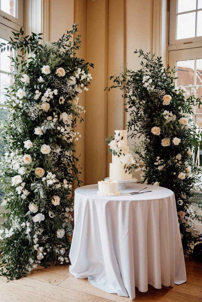 Wedding cake surrounded by florals at Hodsock Priory