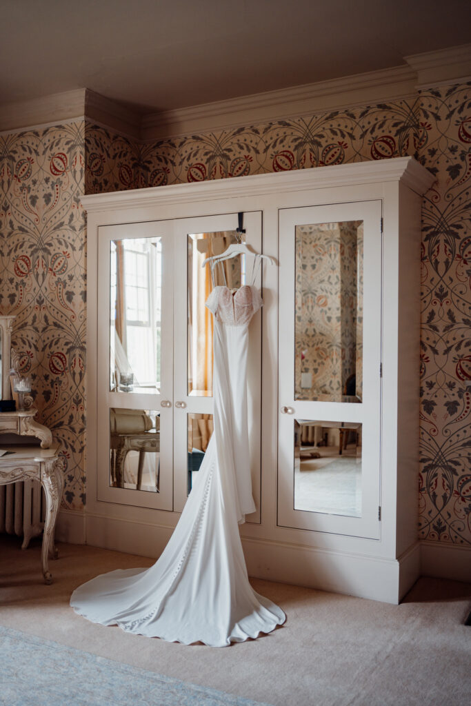 white dress hanging in Hodsock Priory bridal suite