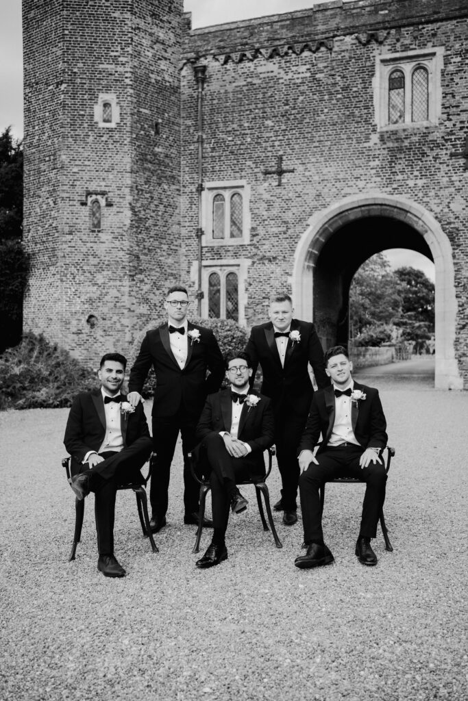 Groomsmen pose for a wedding group shot like a renaissance photo