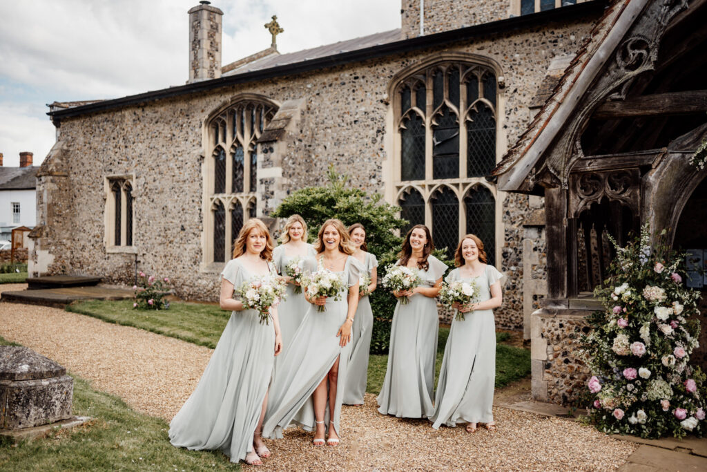 bridesmaids waiting with bouquets outside of church