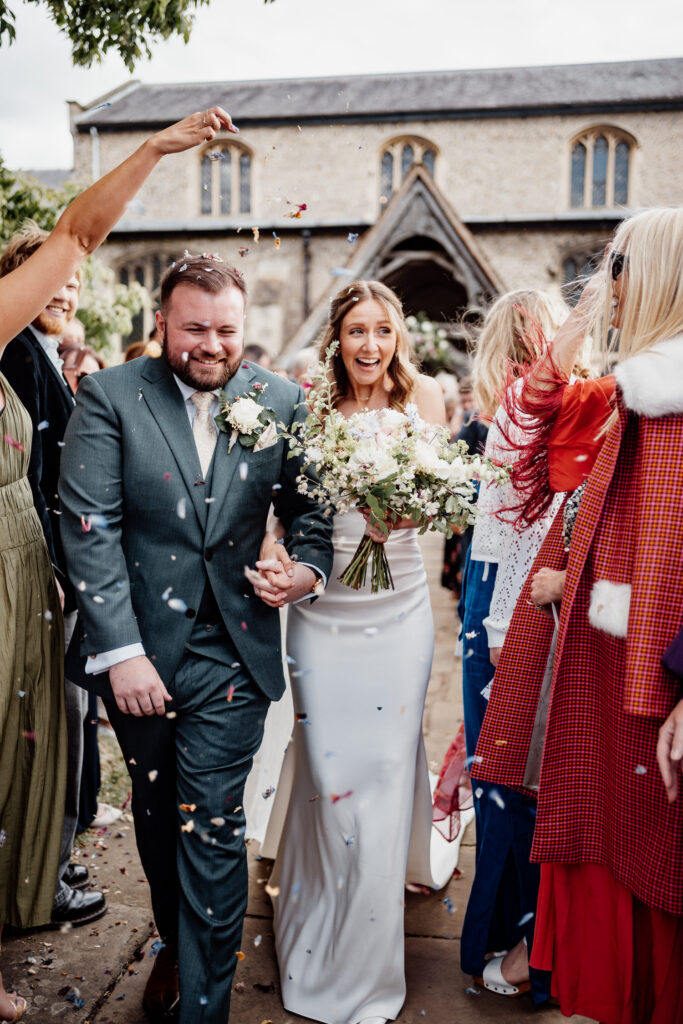 wedding couple getting showered in confetti outside of a church