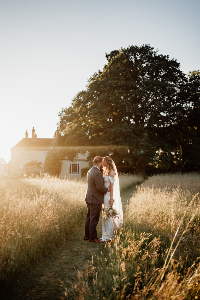 bride and groom kissing in sunset