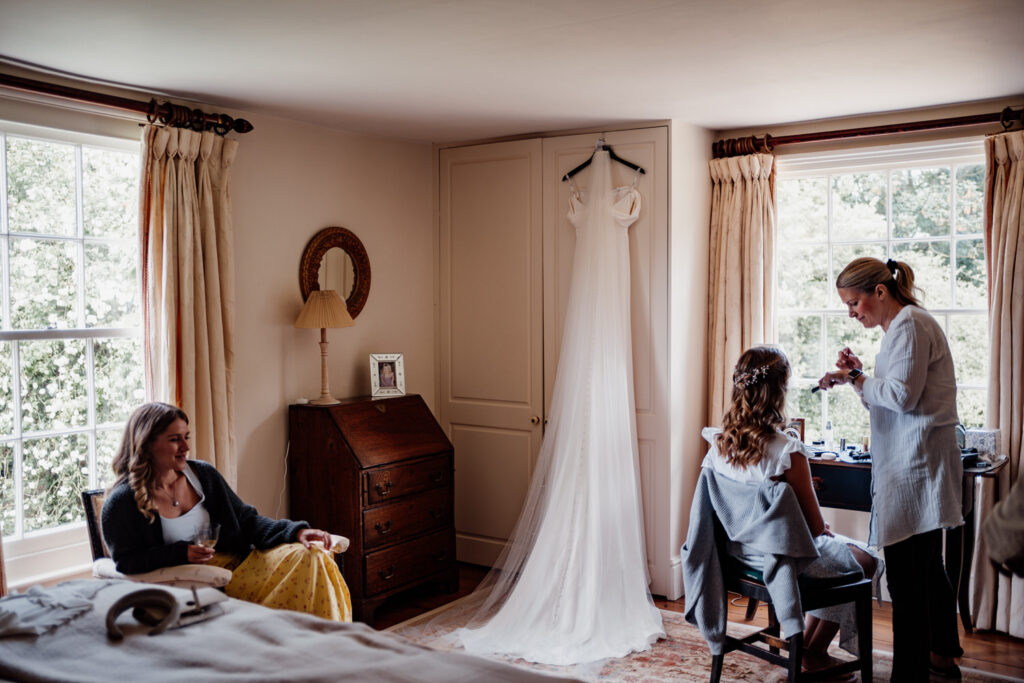 long white wedding dress hung up at bridal prep