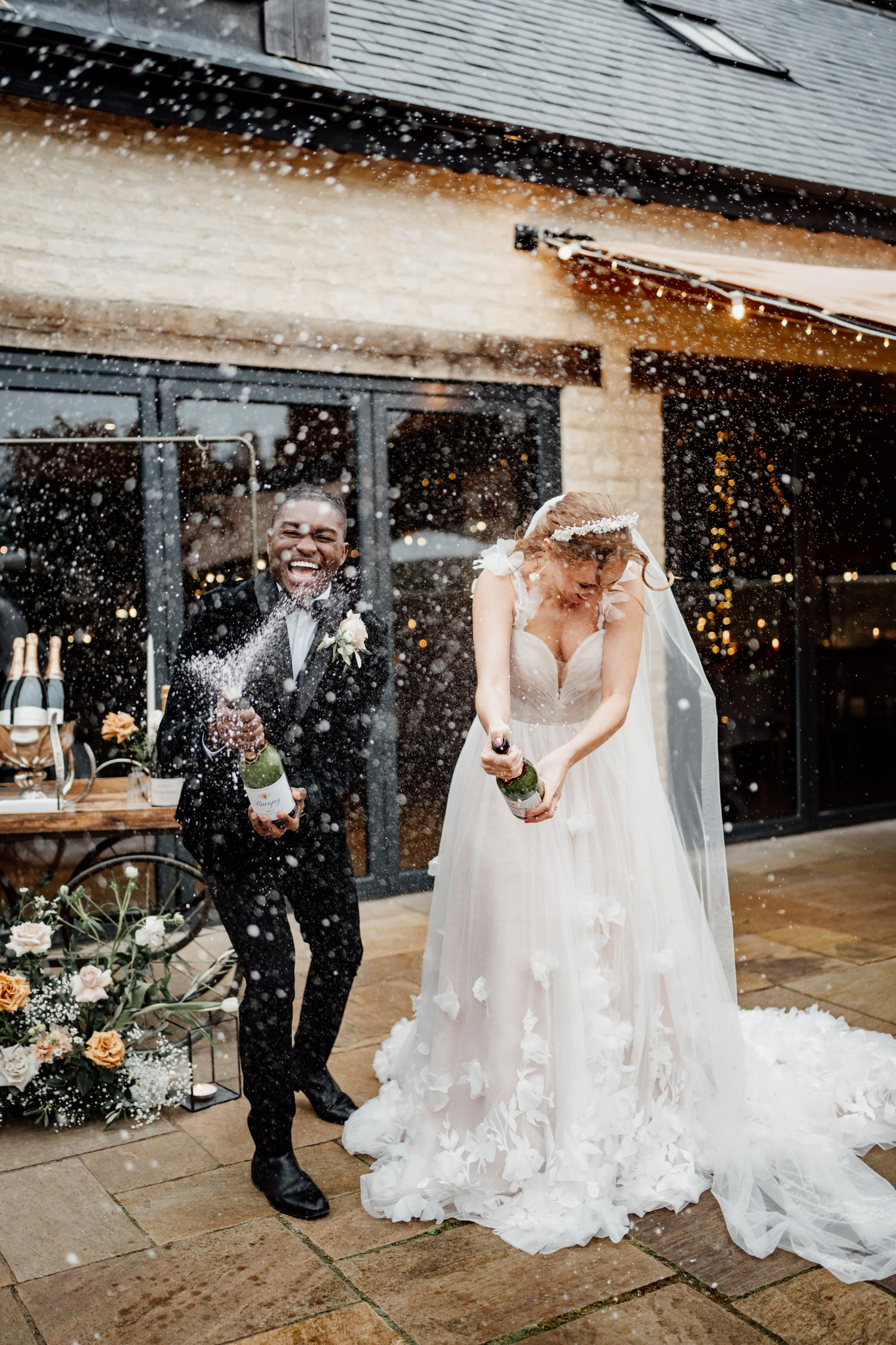 Bride and groom spray champagne