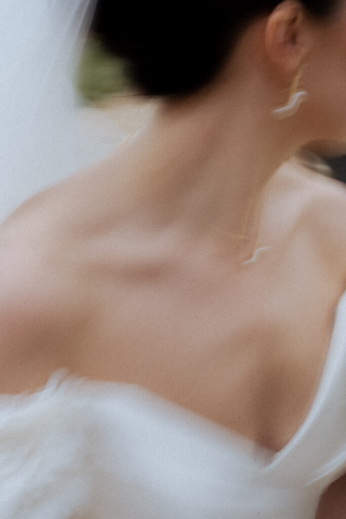 A creatively shot photo of the bride showcasing her jewellery and strapless dress cut.