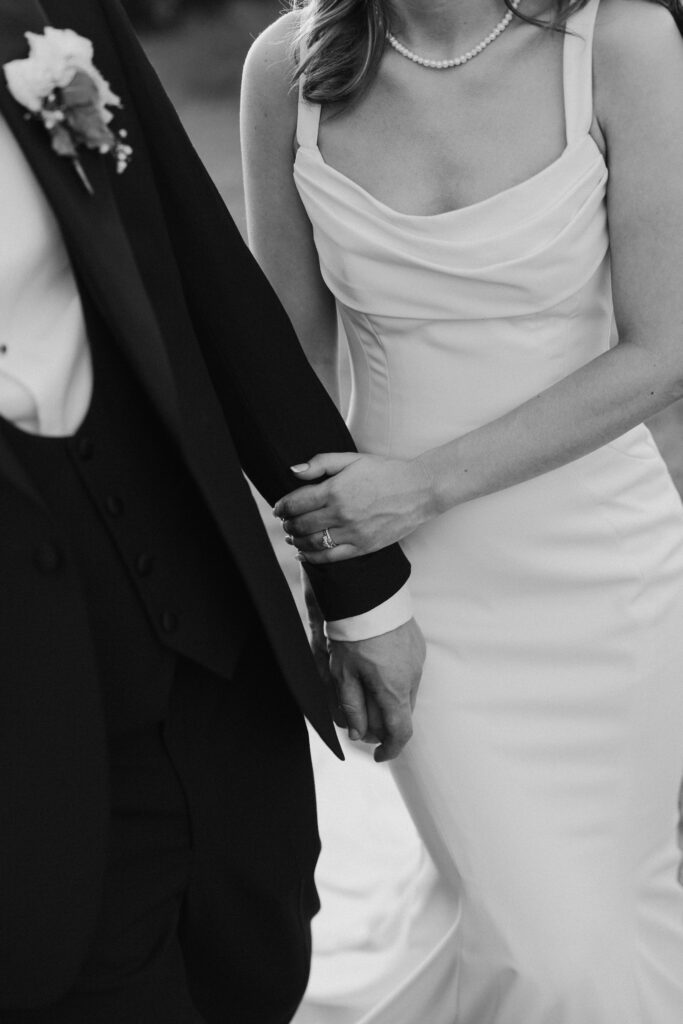 Close up of bride and grooms hands touching, taken from the perspective of a second photographer